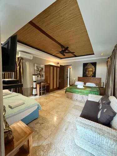 a hotel room with two beds and a couch at Bayshore Residence in Candidasa