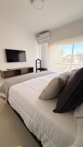 a bedroom with a large bed with a flat screen tv at France Golf Apart - Flat Deluxe con estacionamiento privado, pileta y gimnasio in Río Cuarto