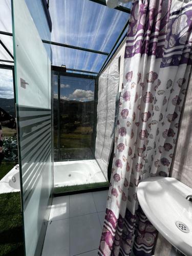 a bathroom with a tub and a sink and a window at Cabaña Bambú - Roca Glamping Suesca in Santa Isabel