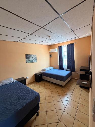 a room with two beds and a tv in it at Cozy beach house getaway in La Libertad
