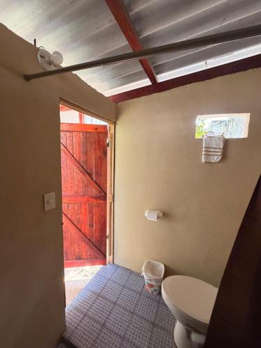a bathroom with a toilet and a barn door at Cozy beach house getaway in La Libertad