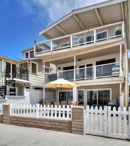 a house with a white fence and an umbrella at 1005 East Balboa in Newport Beach