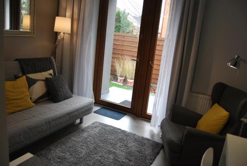 a living room with a couch and a large window at Magnolia Centrum Studio in Wrocław
