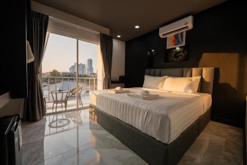 a bedroom with a large bed and a balcony at Aslan Boutique Apartments in Patong Beach
