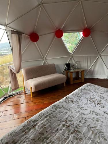 a room with a bed and a couch in a tent at DOMO Roca Glamping Suesca in Suesca