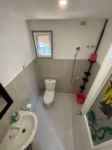 a small bathroom with a toilet and a sink at Poseidon White Sand Resort & Cave in Santa Rosa