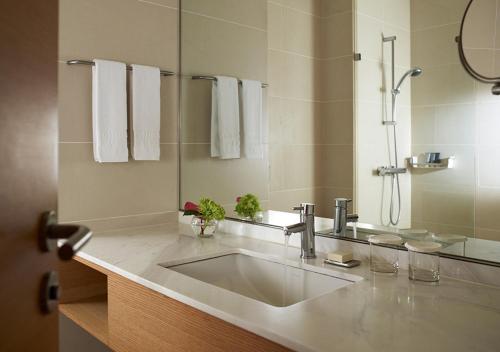 ein Badezimmer mit Waschbecken und Spiegel in der Unterkunft Rolling Hills Hotel in Hwaseong