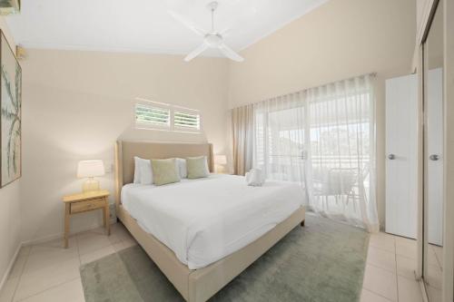 a white bedroom with a large bed and a window at Southwind in Sunrise in Sunrise Beach