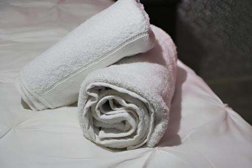 a roll of white towels sitting on top of a bed at Molejo Guest House in Palatswe