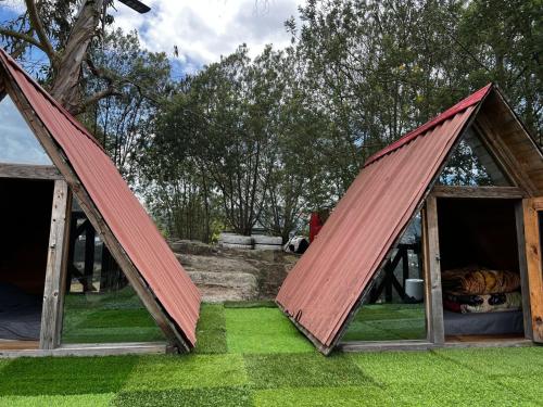 a set of two open doors in a yard with grass at Mini Cabaña Roca Glamping in Suesca