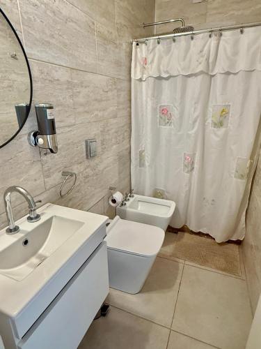 a bathroom with a sink and a toilet and a shower at La Pedrera in Villa María
