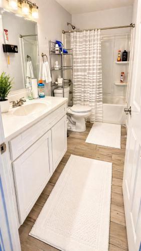 a white bathroom with a sink and a toilet at Penn Signature Airport Short Term Rental PHX in Phoenix