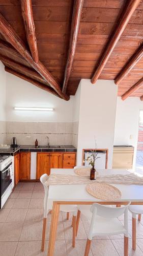a kitchen with a white table and white chairs at Trono de Nubes in Trevelín