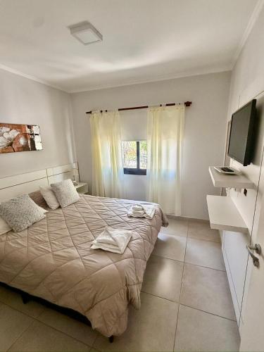 a bedroom with a bed and a television in it at La Pedrera in Villa María