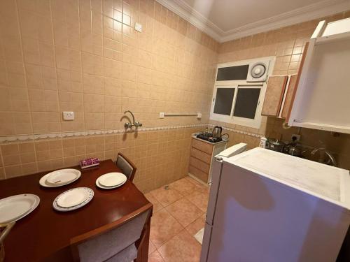 a small kitchen with two sinks and a refrigerator at شركه أركان الذهبيه الحديثه للشقق المخدومه in Abha