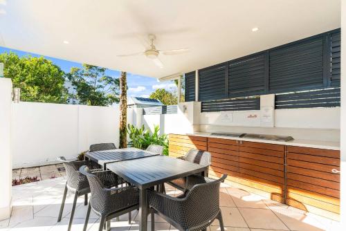 an outdoor patio with a table and chairs at Immaculate Riverside Apartment With Heated Pool in Noosaville