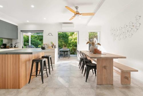 a kitchen with a wooden table and chairs at Whispering Waves Pet Friendly Steps to Beach in Peregian Beach