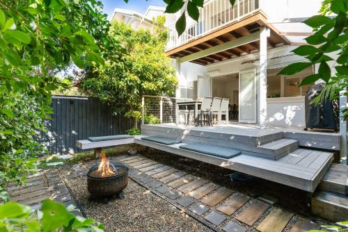 a patio with a fire pit in front of a house at Whispering Waves Pet Friendly Steps to Beach in Peregian Beach