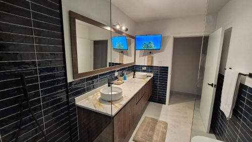 a bathroom with two sinks and a large mirror at Stunning seaside villa with pool and jacuzzi in Boca Chica