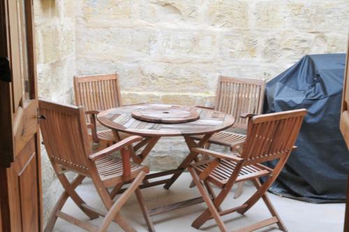 a wooden table and chairs on a patio at St Elias Apartment in St. Julianʼs