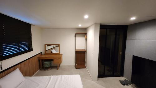 a bedroom with a bed and a desk and a television at Jin Stay Hotel in Changwon