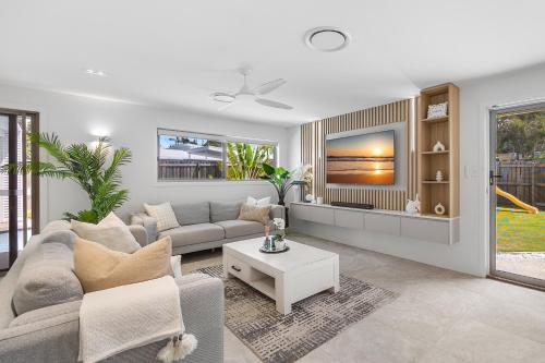 a living room with a couch and a table at Spacious 4-Bed Coastal Home with Pool in Mooloolaba