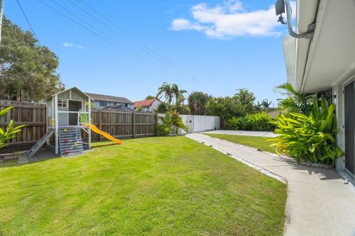 a yard with a playground in a backyard at Spacious 4-Bed Coastal Home with Pool in Mooloolaba