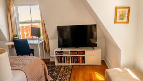 a living room with a tv and a bed and a staircase at College Hill 2BR, Walk to Brown & RISD, Free Parking in Providence