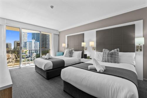 a hotel room with two beds and a balcony at Ocean View Suite 2 Beds Wi-Fi Netflix in Gold Coast