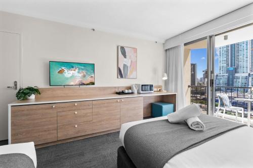 a bedroom with a bed and a dresser with a tv at Ocean View Suite 2 Beds Wi-Fi Netflix in Gold Coast