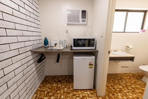 a kitchen with a counter with a microwave and a refrigerator at Hotel Clipper in Rockingham
