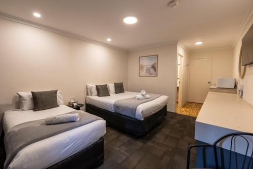 a hotel room with two beds and a kitchen at Hotel Clipper in Rockingham