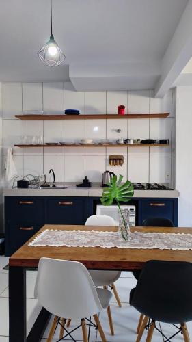 a kitchen with blue cabinets and a table with chairs at Aconchego e Estilo em Brusque in Brusque