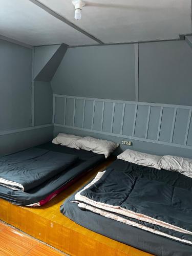 two beds sitting in a room with a wall at Artana cabin in Palayangan