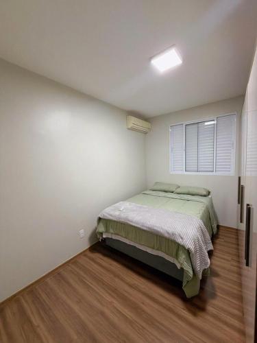 a bedroom with a bed and a window in it at Apartamento com academia - Toledo in Toledo