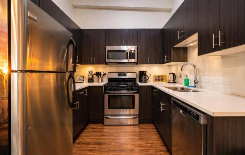a kitchen with stainless steel appliances and wooden cabinets at Spacious 3BR 420 Friendly Apartment Near McCormick Place, Lakefront and Soldier Field in Chicago