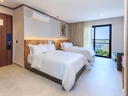 two beds in a hotel room with a balcony at Brada Collection Stays in Guadalajara