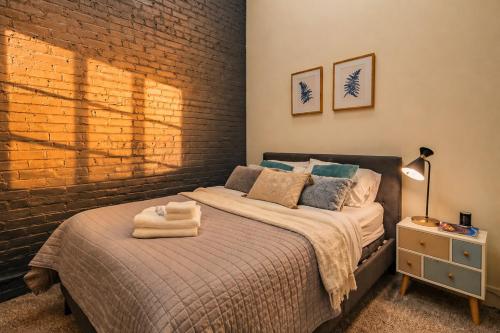 a bedroom with a bed and a brick wall at Modern 2BR 420 Friendly in Chicago South Loop Near Museum Campus, McCormick Place and Soldier Field in Chicago
