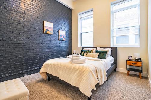a bedroom with a bed and a brick wall at Modern 2BR 420 Friendly in Chicago South Loop Near Museum Campus, McCormick Place and Soldier Field in Chicago