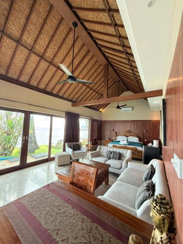 a living room with a couch and a bed at Bayshore Villa in Candidasa
