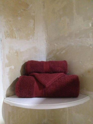 three red towels sitting on a shelf in a room at Birgu Studio Maisonette in Birgu