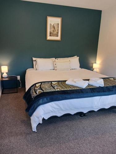 a bedroom with a large bed with a green wall at Suncrest Villas in Cromwell