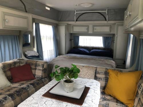 a living room with a bed and couch in an rv at Tamesis - Wildernest in Neranie