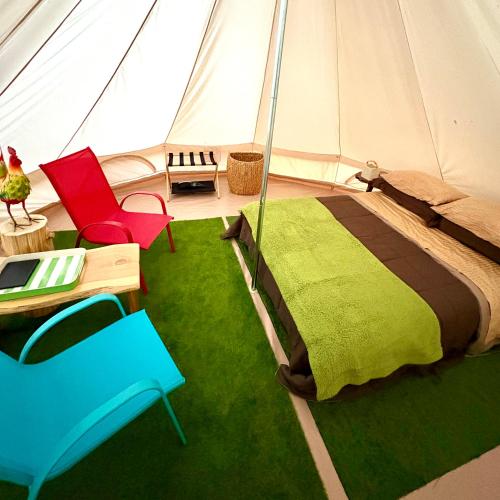 ein Schlafzimmer in einem Zelt mit Bett und Stühlen in der Unterkunft Basecamp3105 in Sooke