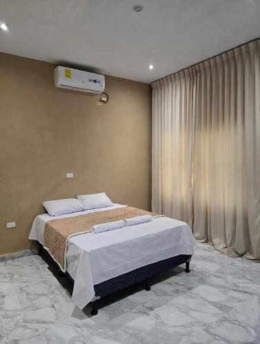 a bedroom with a large bed and a window at "Selva maya stay" kitchen and spacious private parking in Flores