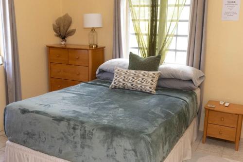 a bedroom with a bed and a dresser and a window at Cozy Cottage in Woods