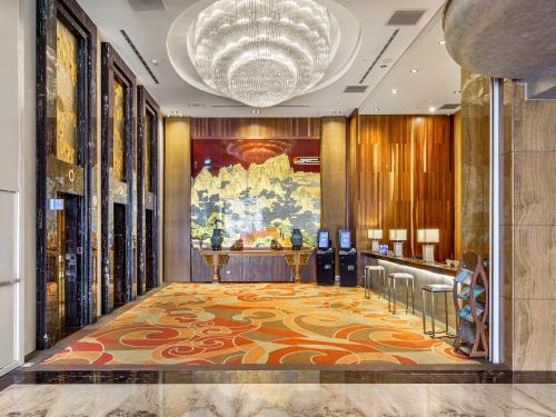 a lobby with a large painting on the wall at CHECK inn Select Tainan Yongkang in Yongkang