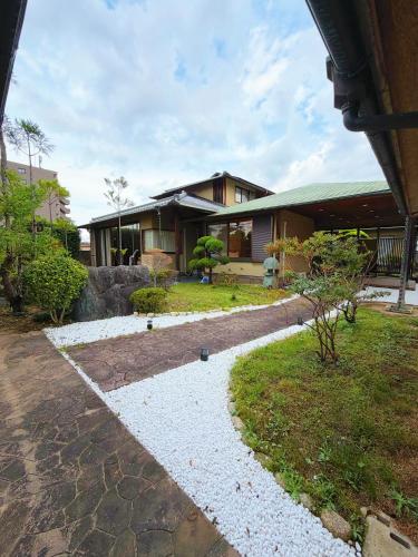 a house with a walkway in front of a yard at 红尘会馆 in Kishiwada