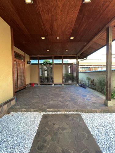 an empty room with a wooden ceiling and a patio at 红尘会馆 in Kishiwada