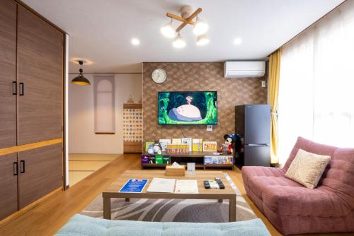 a living room with a couch and a table at New 充実設備&コスパ&快適重視の宿!空港美瑛富良野スキー場4ヵ所アクセス良!キッズエリア大人気 in Asahikawa